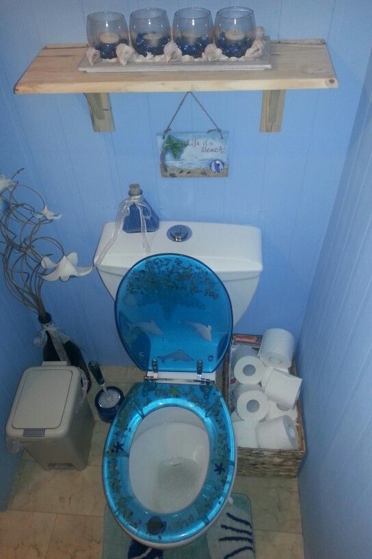 a blue toilet sitting in a bathroom next to a shelf