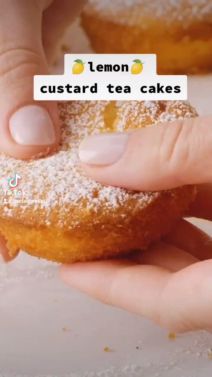 a person holding a sugar covered doughnut in their hand with the caption lemon custard tea cakes