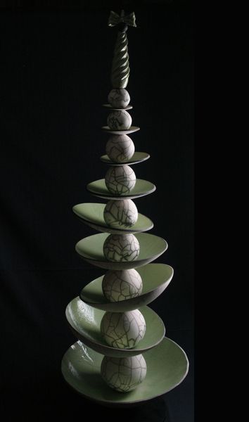 a stack of plates with balls stacked on each other in the shape of a christmas tree