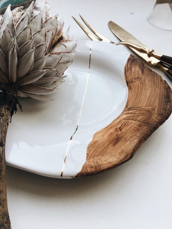 a white plate topped with an artichoke next to a fork and knife