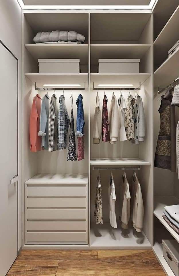 an organized closet with clothes hanging on shelves