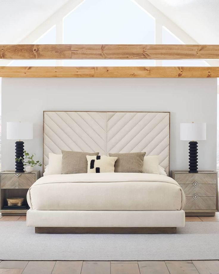 a large white bed sitting inside of a bedroom