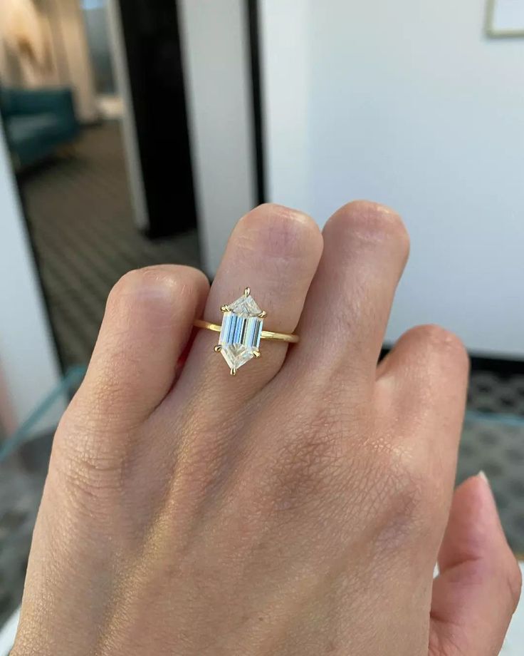 a woman's hand holding a ring with an aqua blue topazte on it