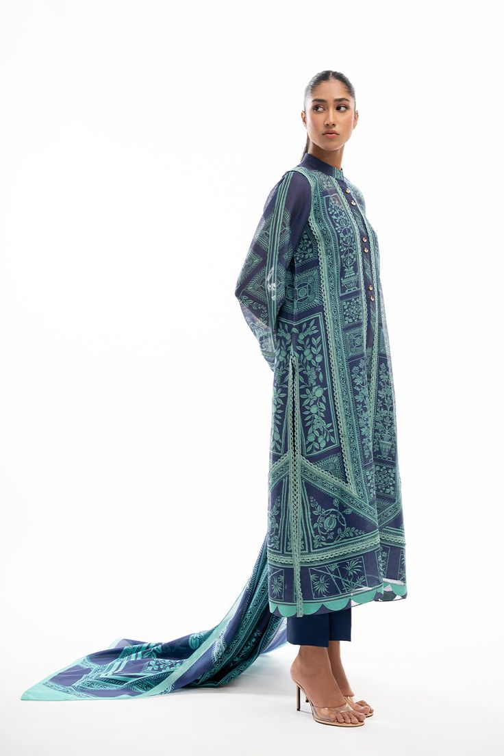 A printed navy blue cotton net shirt is adorned with elegant lacework in a turquoise hue and scalloped edging. Featuring worked buttons on the neckline, the shirt is paired with a matching printed dupatta and rawsilk trousers. Bohemian Blue Palazzo Set With Printed Motifs, Blue Silk Palazzo Set With Sheer Dupatta, Blue Anarkali Style Cotton Silk Palazzo Set, Blue Anarkali Palazzo Set In Cotton Silk, Bohemian Blue Sets With Digital Print, Bohemian Blue Digital Print Sets, Blue Dresses With Resham Embroidery In Cotton Silk, Blue Cotton Silk Salwar Kameez With Sheer Dupatta, Blue Bohemian Kurta With Dupatta