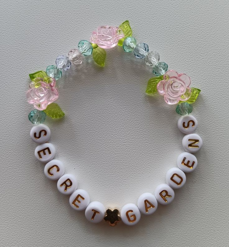 a white beaded bracelet with flowers and words that say send garden on the front