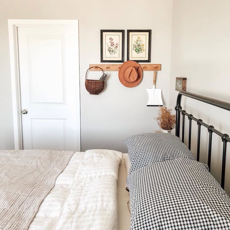 a bedroom with a bed, hat rack and pictures on the wall