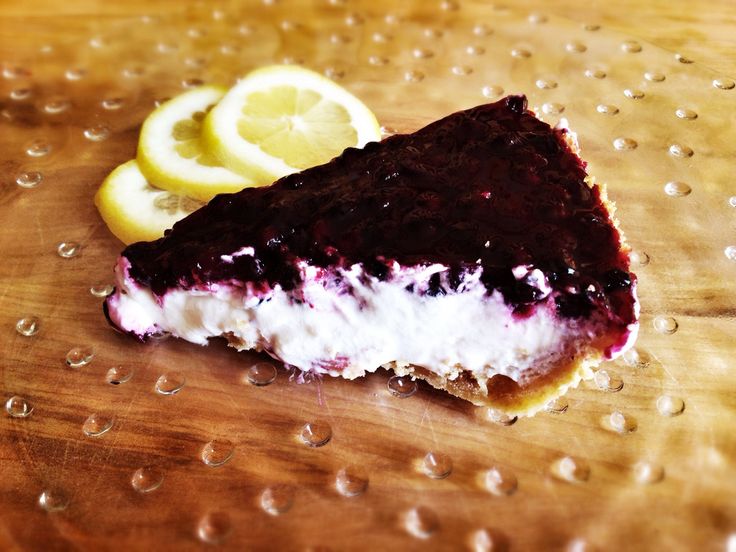 a piece of cake with blueberries and lemon slices