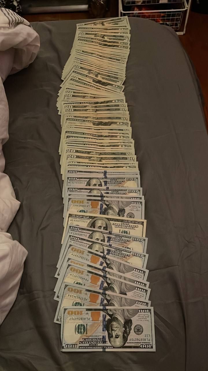 a pile of money sitting on top of a bed