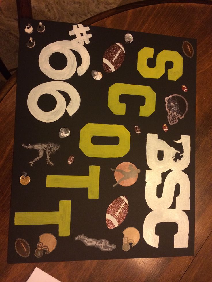 a black sign with yellow letters on it and some sports related items in the bottom right corner