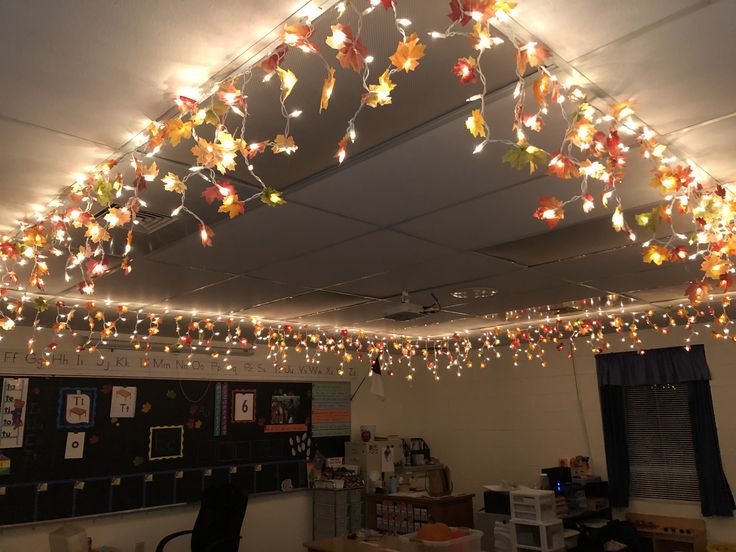 an office decorated for christmas with lights hanging from the ceiling