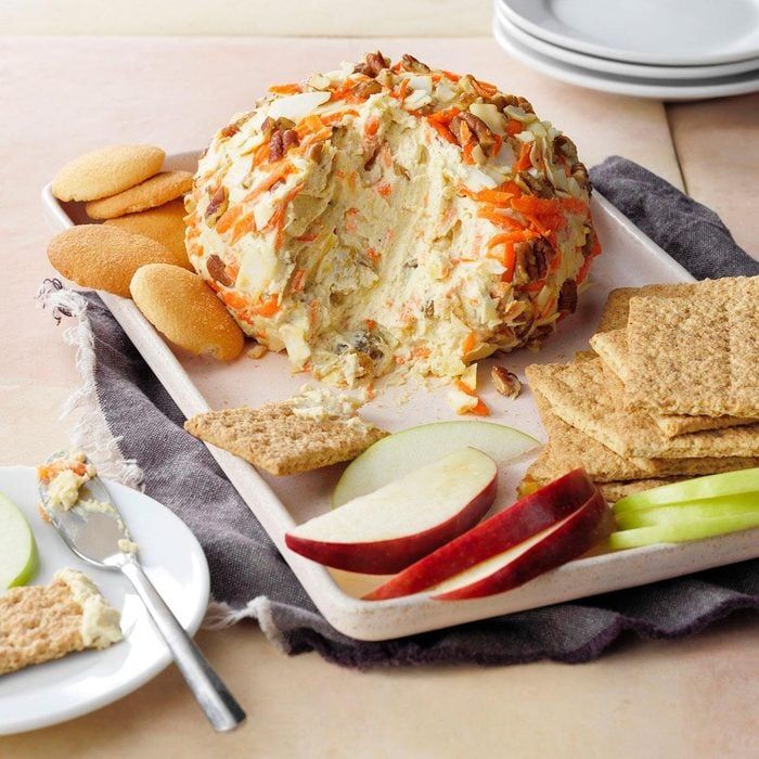 a plate with crackers, apple slices and cheese ball sitting on top of it