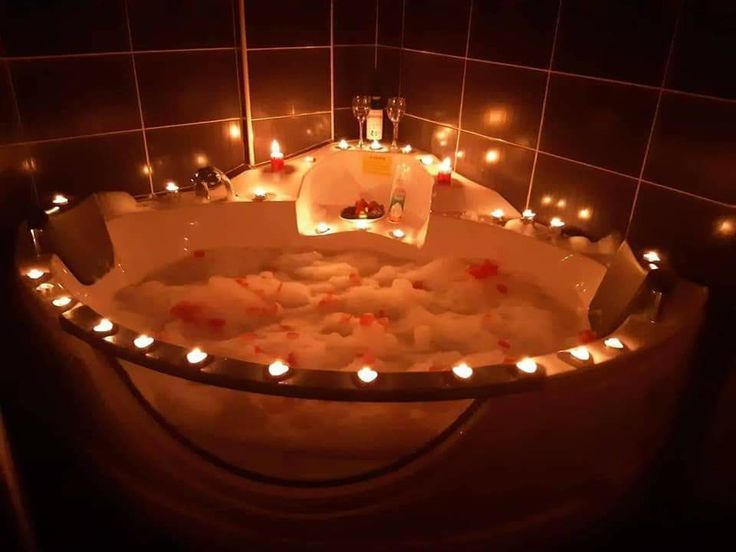 a bathtub filled with lots of water and candles