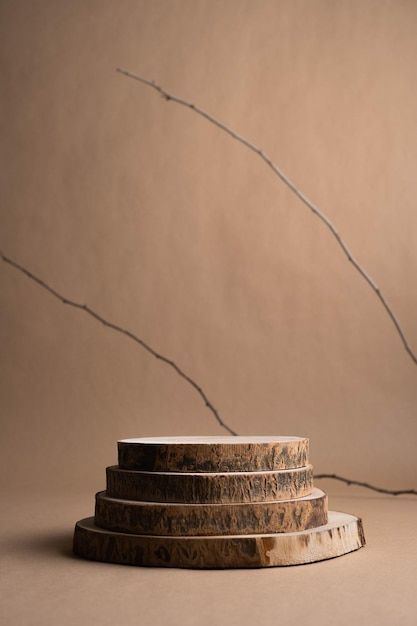 three stacked marble pedestals in front of a brown wall with an artistic plant growing out of the top