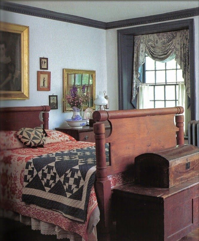 a bedroom with a bed, dresser and window in the corner next to an old chest