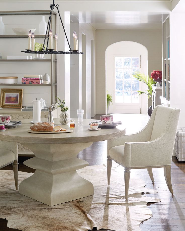 a dining room table with two chairs around it and a chandelier hanging from the ceiling