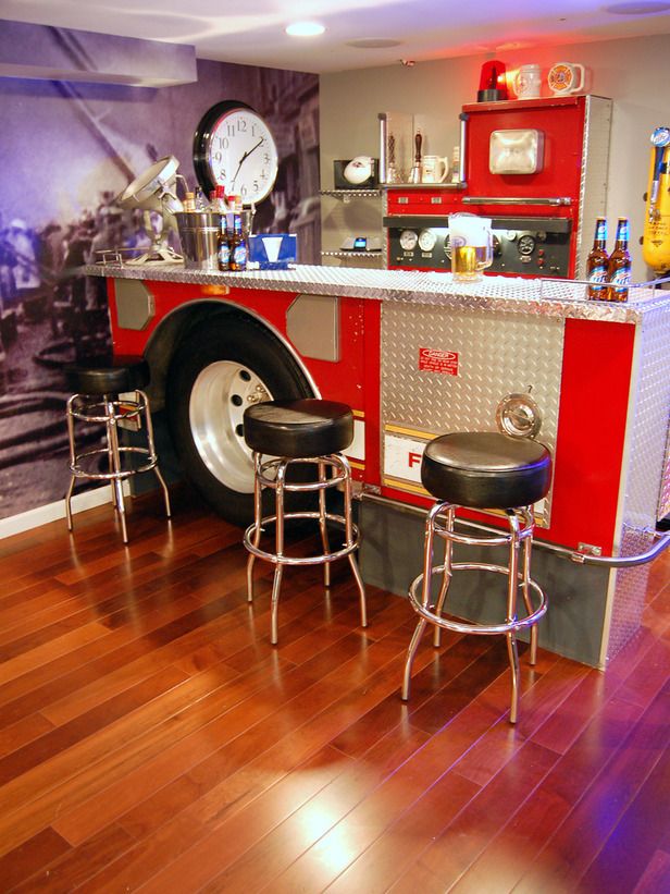 a firetruck themed bar with stools in a room that has wood floors