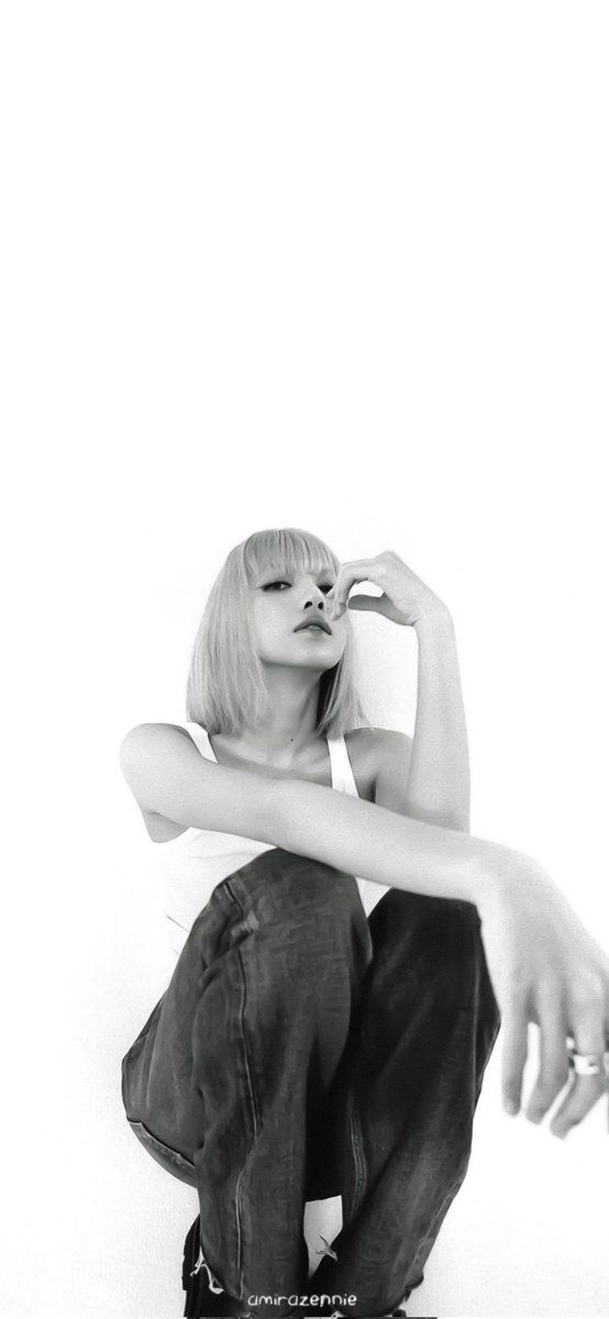 a black and white photo of a woman sitting on the ground with her hands behind her head