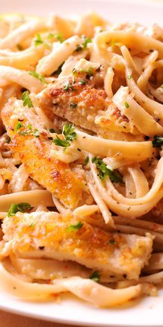 pasta with chicken and parsley on a white plate