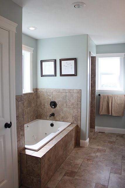 a bathroom with a large tub and tiled floors