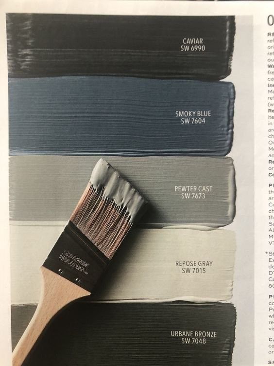 an open book with some paint colors and a brush in the middle one is showing different shades of gray