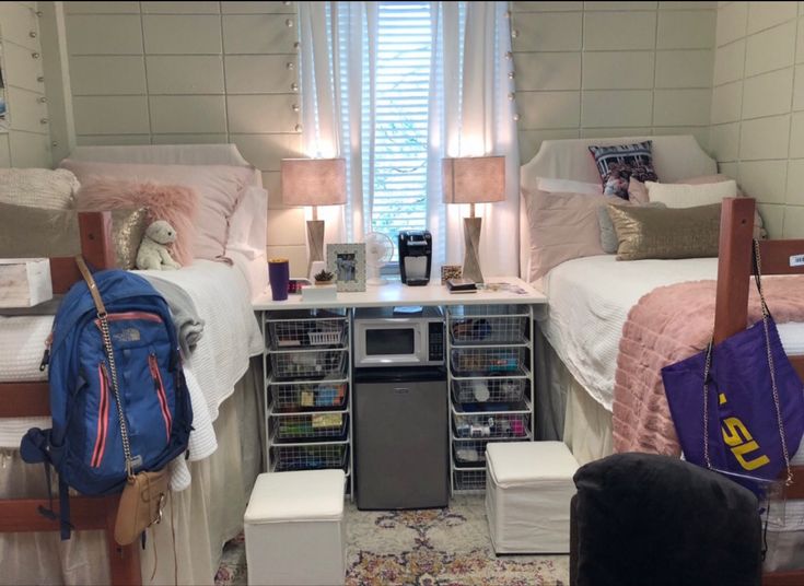 two twin beds in a dorm room with luggage on the floor