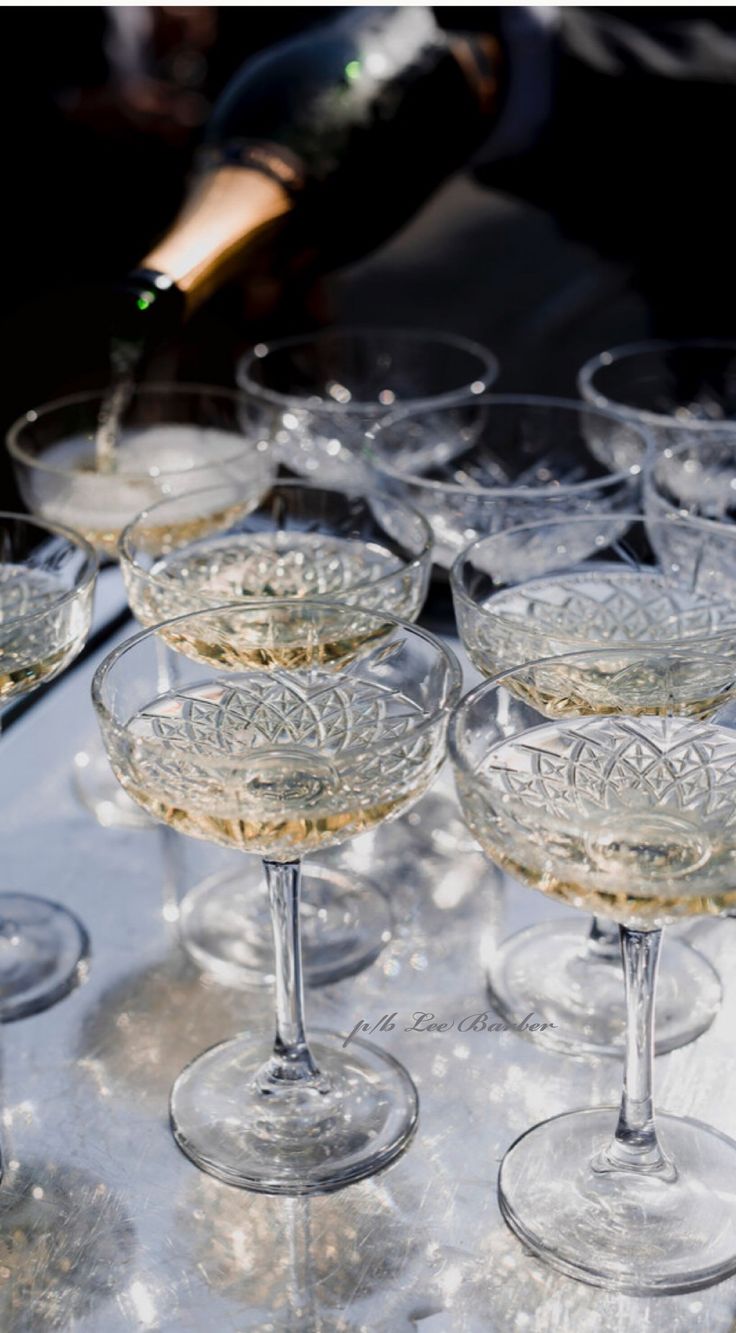 many wine glasses are lined up on a table