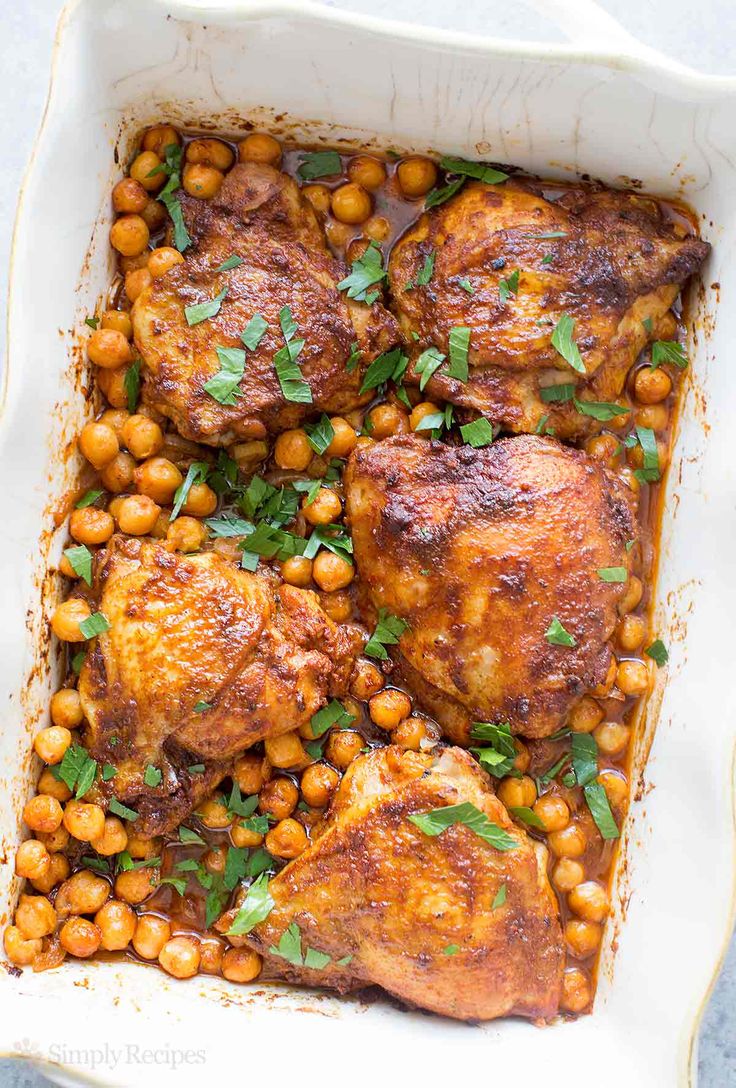 chicken and chickpeas in a white casserole dish with garnish