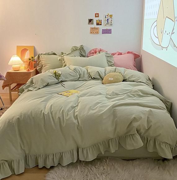 a bed room with a neatly made bed and a projector screen on the wall