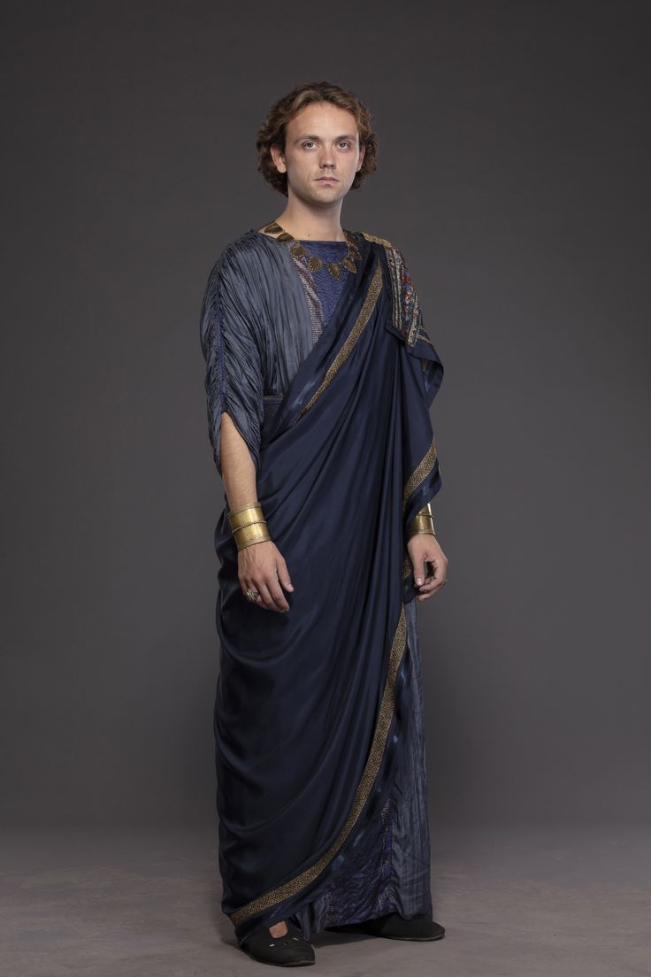 a man dressed in an ancient greek costume posing for the camera with his hands on his hips