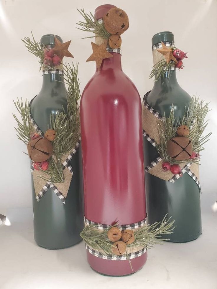 three wine bottles decorated with christmas decorations