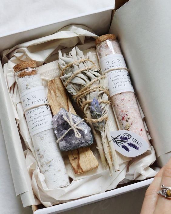 a box filled with different types of soaps and spices next to a person's hand