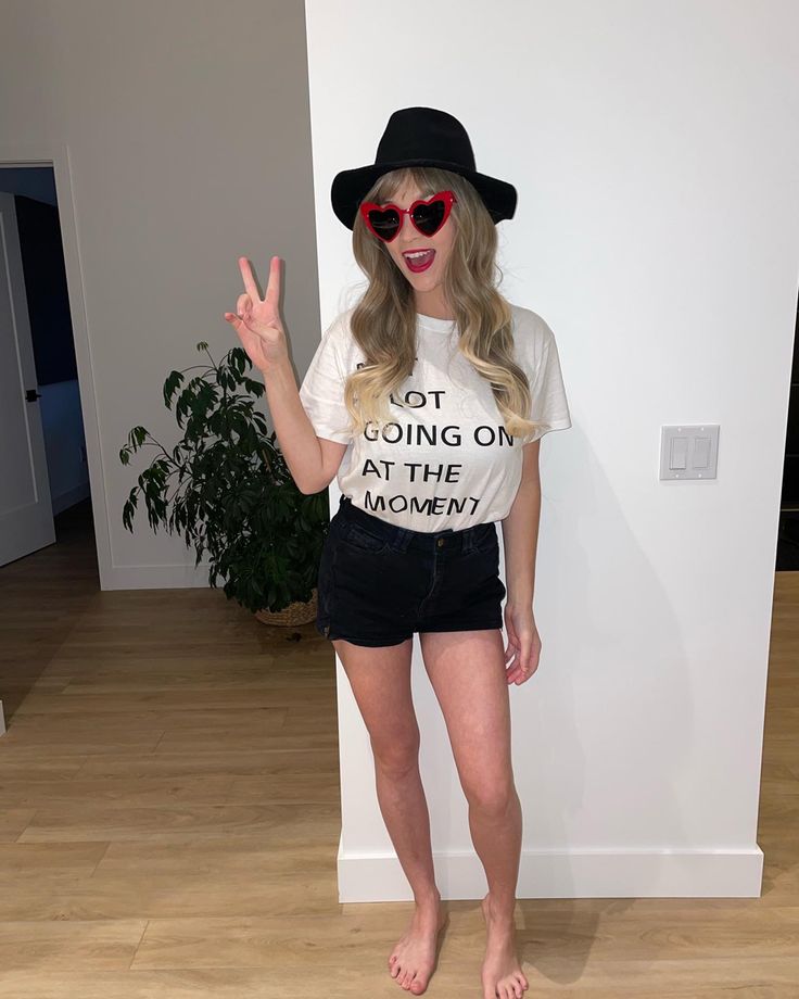 a woman in black shorts and a white t - shirt is posing for the camera