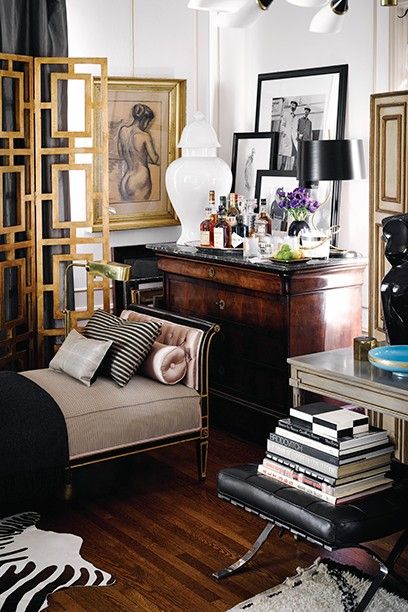 a living room filled with lots of furniture and pictures on the wall next to a dresser