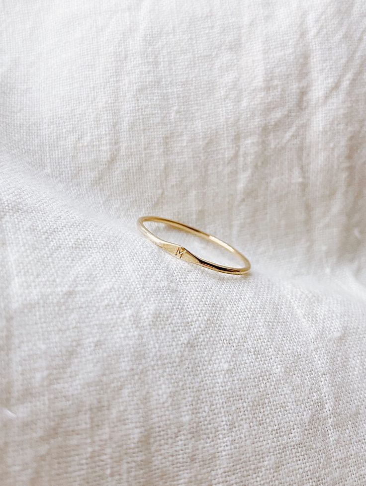 MICRO SIGNET RING A solid 14k gold ring that has a dimple on a ring with a tiny initial/letter of choice. Each ring is madd-to-order with love and is carefully handcrafted (may be slightly different than picture). This is a perfect everyday ring that is great for gifting. + 1mm band solid 14k Yellow Gold ring + Micro initial + Comes in a box + Available characters in Capital letters from dropdown bar: A B C D E F G H I J K L M N O P Q R S T U V W X Y Z + Please note all Mantle 14k gold pieces ar M Jewelry Letter, M Ring Letter, 14k Yellow Gold Initial Ring For Everyday, Dainty 14k Gold Initial Ring Tarnish Resistant, Simple Yellow Gold Initial Ring For Anniversary, 14k Gold Open Ring With Birthstone, Simple Initial Ring With Round Band For Promise, Simple Initial Ring For Promise, Dainty 14k Gold Initial Ring With Round Band