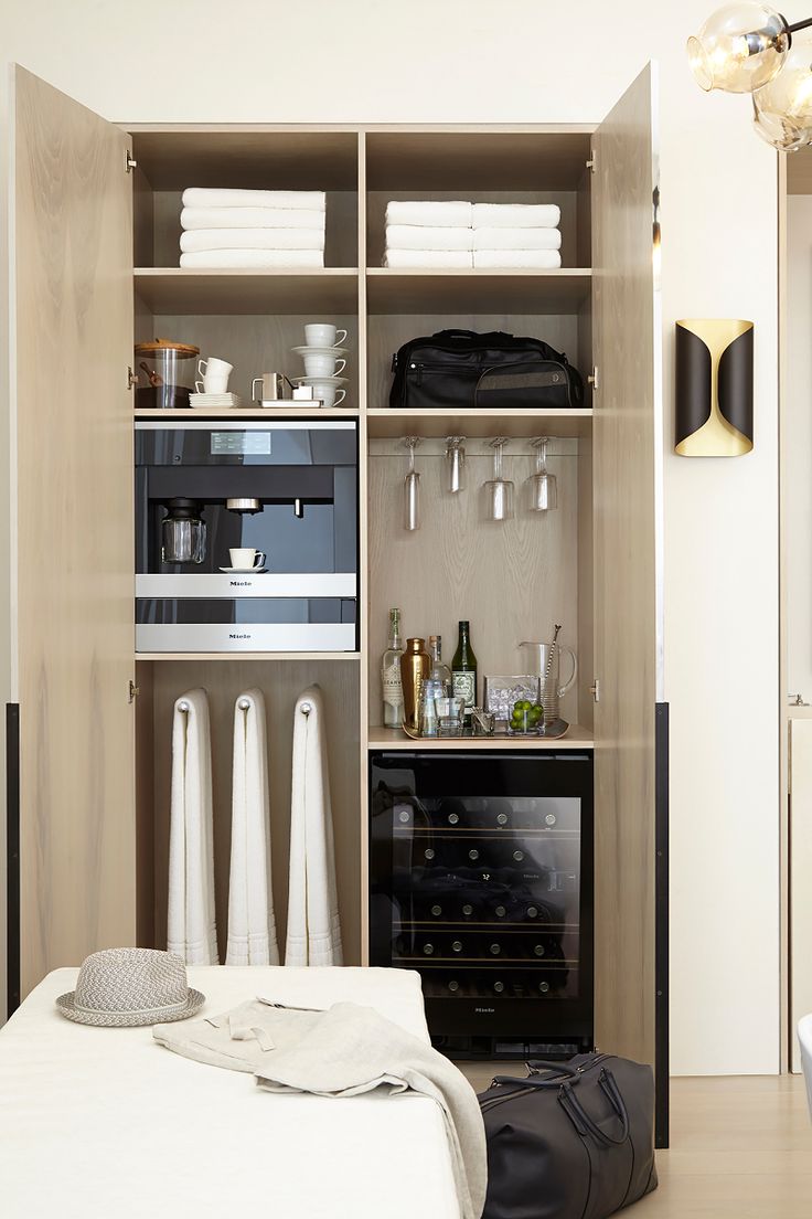 an open closet with towels, wine bottles and other items on it's shelves