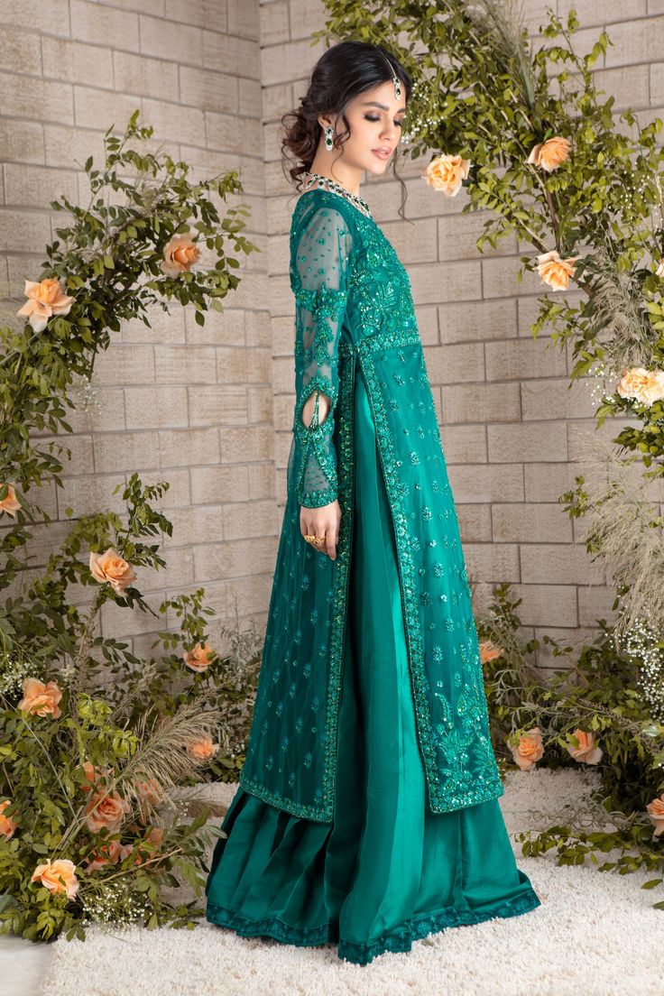 Emerald hued net front-open heavily embroidered jacket featuring glistening sequins, beads, pearls, crystals, stones and silk thread embroidery, attached to pure raw silk pleated gown, paired with heavily sequins embellished net dupatta, a wardrobe must have this wedding season. Gown Fabric: Net & Pure Raw SilkLength: Jacket length 48”, Gown Length 58” (max length)Dupatta Fabric: Net Color: Emerald Green This is a two-piece outfit including gown & Draped dupatta. All outfits are fully lined Lini Silk Thread Embroidery, Pleated Gown, Designer Outfit, Net Dupatta, Pakistani Designers, Thread Embroidery, Crystals Stones, Embroidered Jacket, Silk Thread