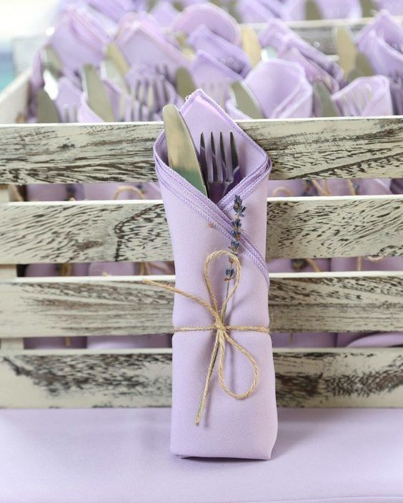 purple napkins and forks are wrapped in twine