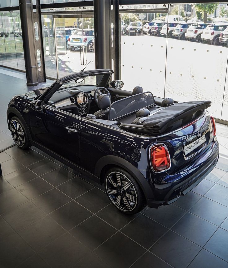 a convertible car is parked in a showroom