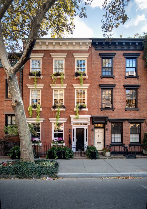 an apartment building with many windows and plants on the front