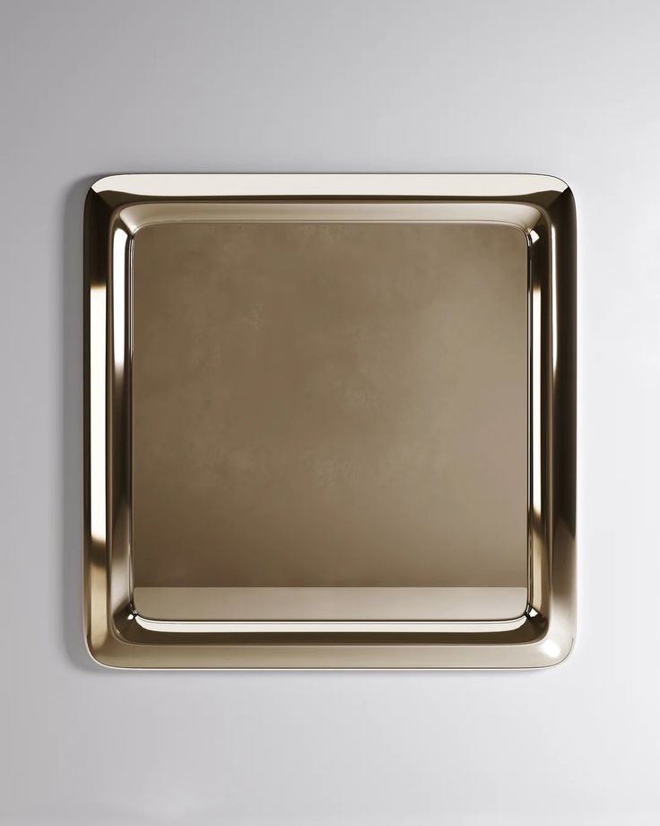 a square mirror mounted to the side of a wall