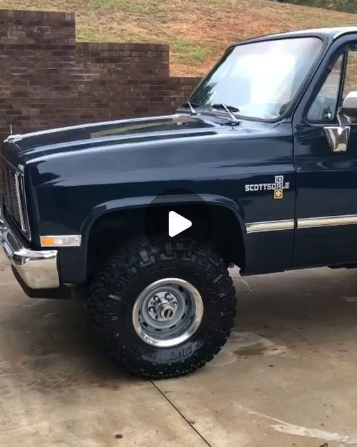 a blue truck parked on top of a driveway