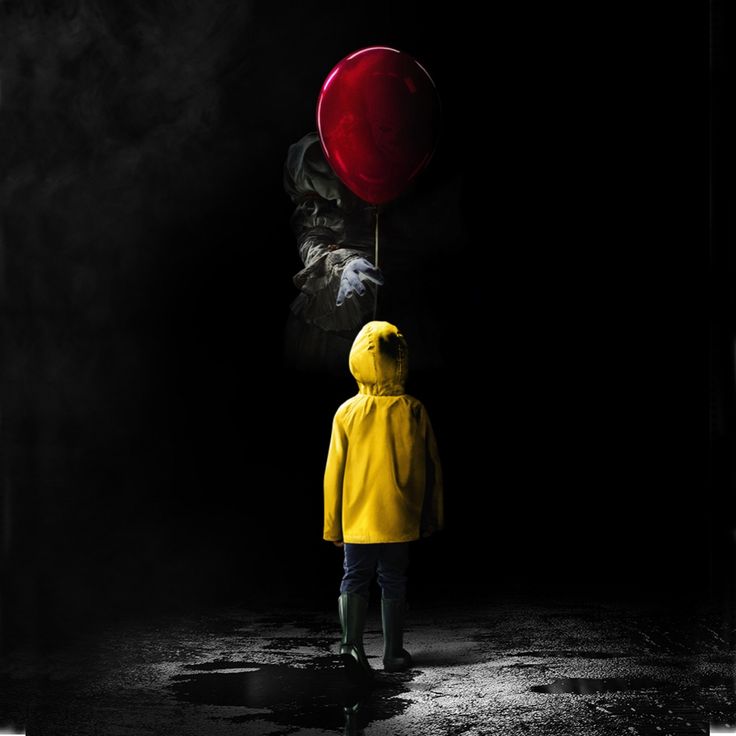 a person in yellow raincoat holding a red balloon