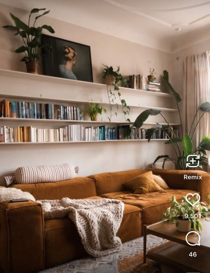 a living room filled with lots of furniture and bookshelves above a window covered in plants