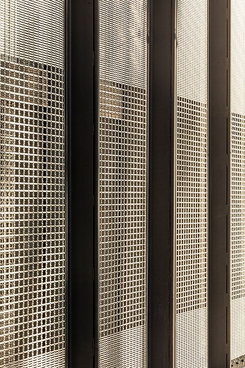 three black and white metal partitions with perfored screens on the wall next to each other