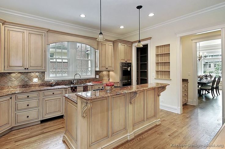 a large kitchen with wooden floors and cabinets