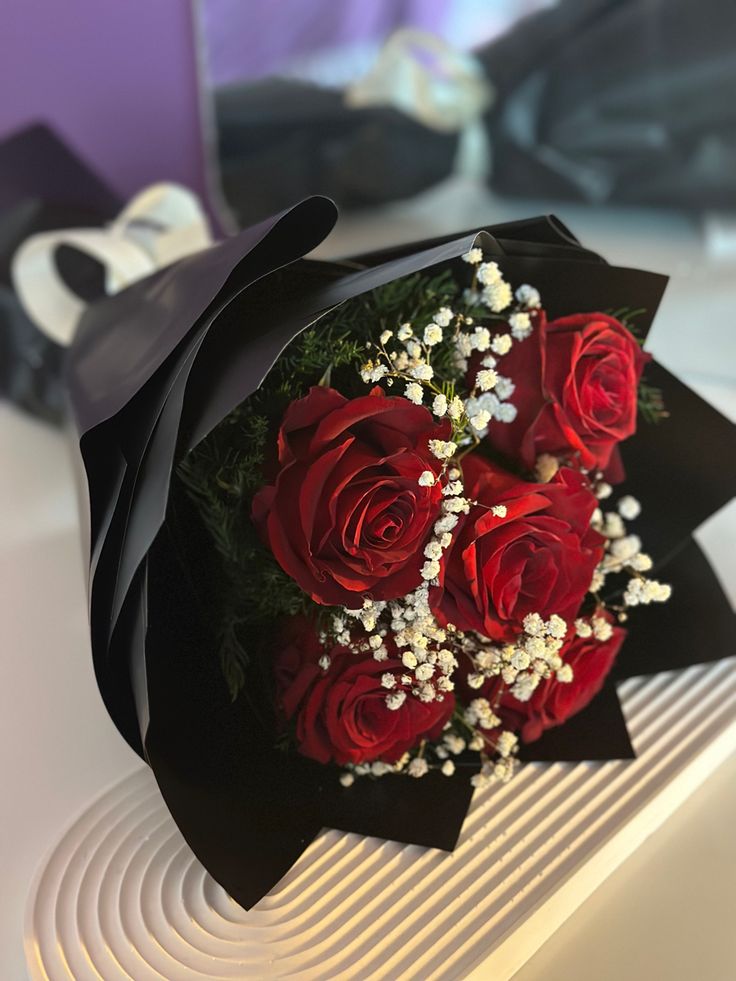 a bouquet of red roses sitting on top of a table