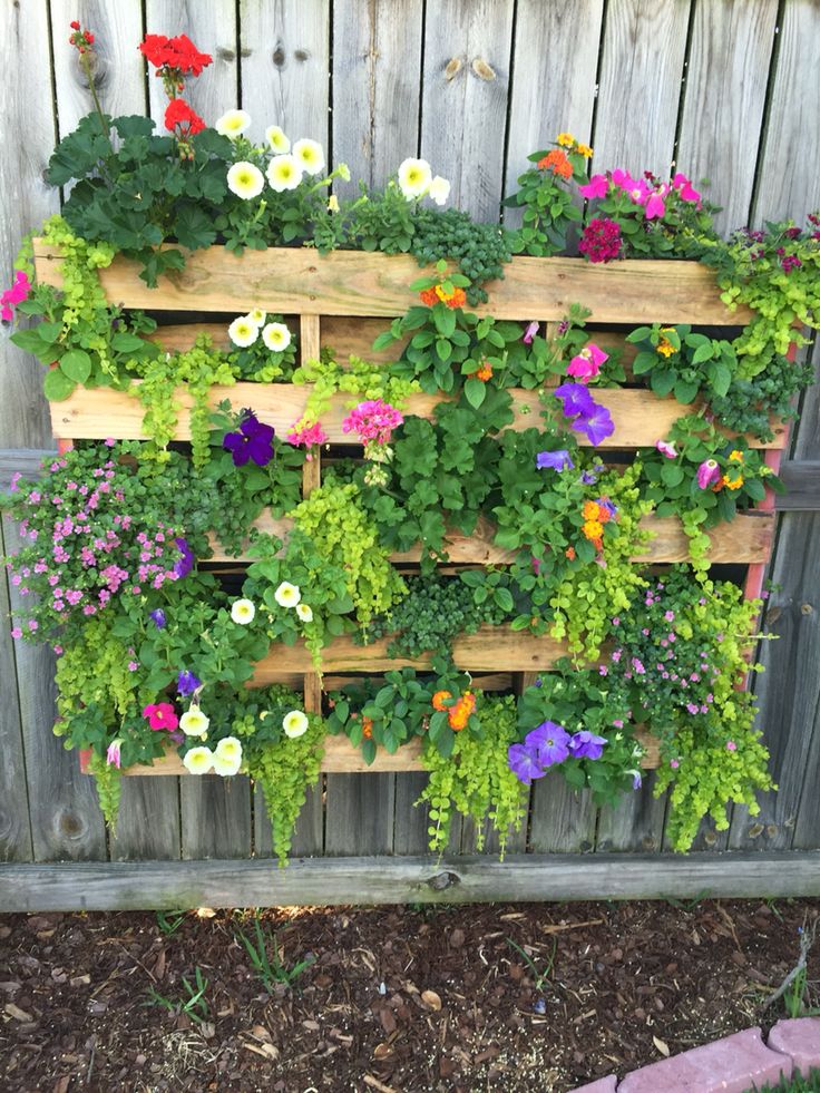 a wooden planter filled with lots of flowers