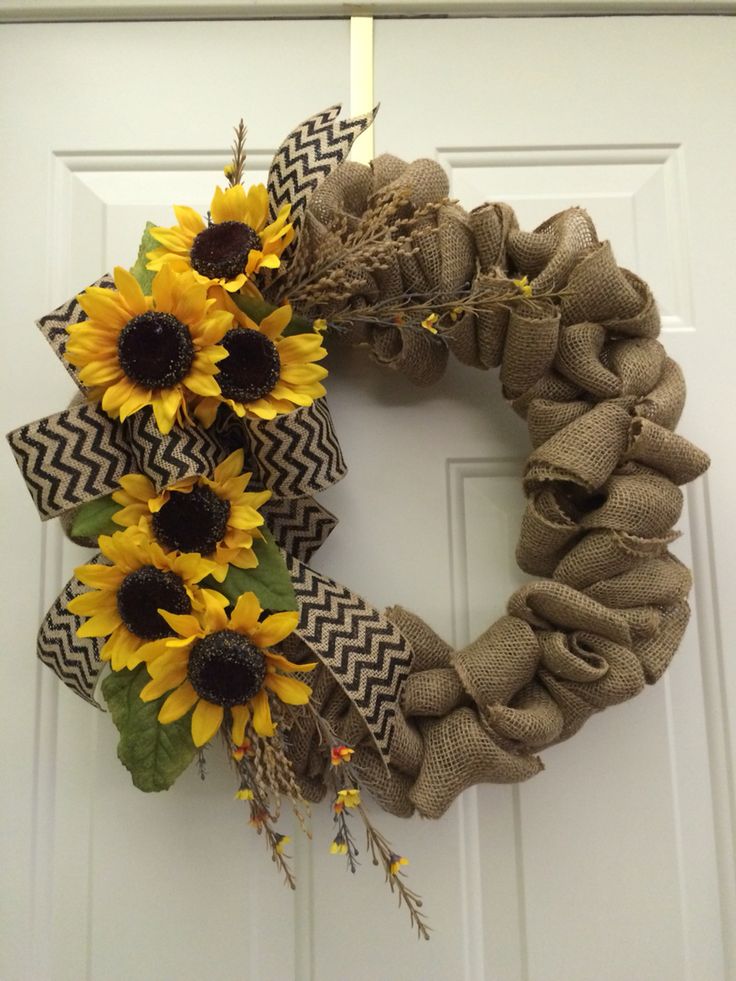 a wreath with sunflowers and burlocks on the front door