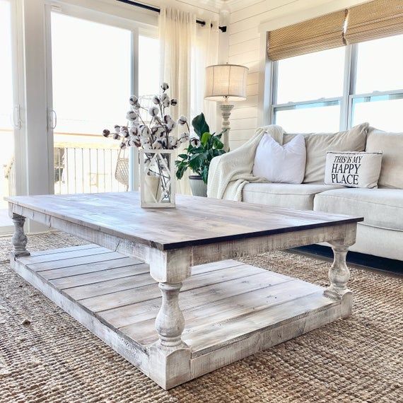 a living room with couches and a coffee table in the middle of the room