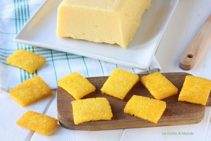 several pieces of yellow cake on a wooden cutting board